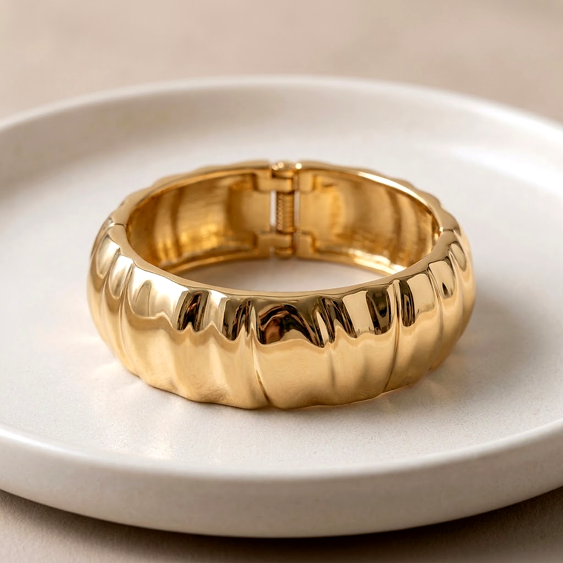 Bracelete dourado largo com relevo ondulado