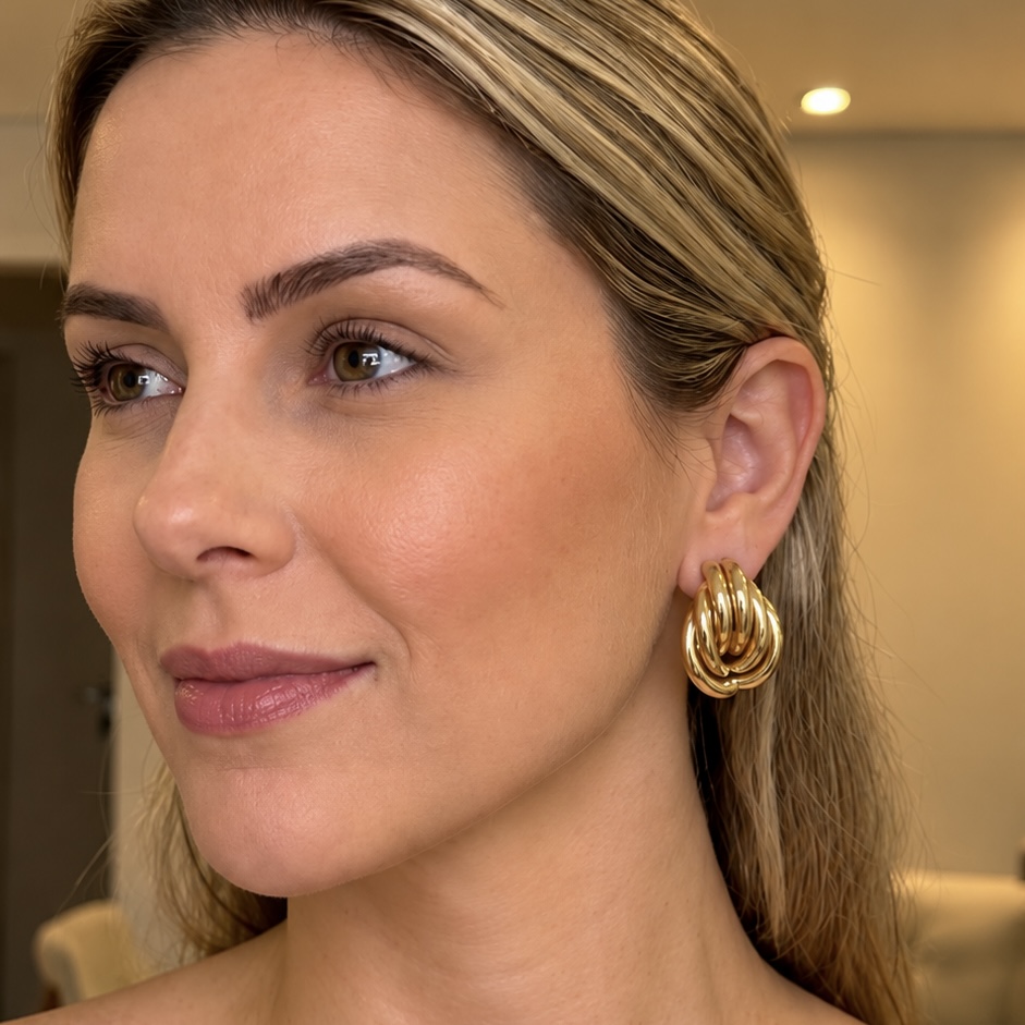 Modelo usando brinco nó entrelaçado dourado