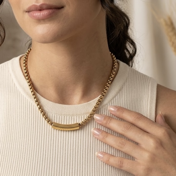Colar dourado de correntaria com placa central usado pela modelo