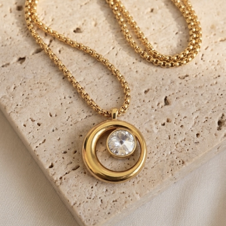 Colar longo dourado com pingente circular e ponto de luz