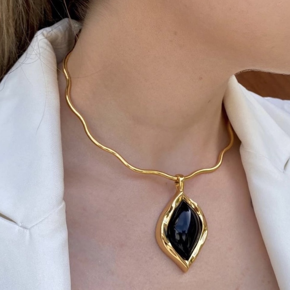 Modelo usando colar onda dourado com pingente navete preto
